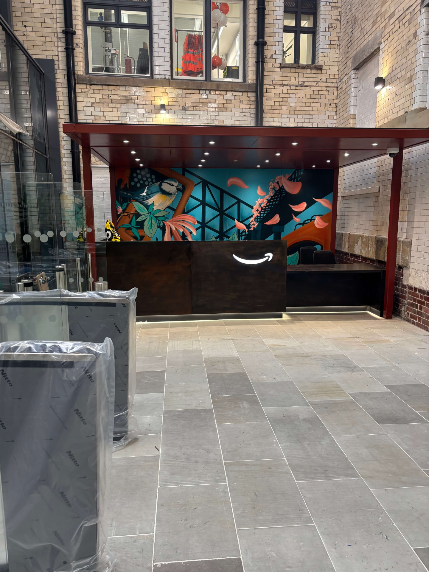 Amazon reception desk with the Amazon smile logo and mural wall