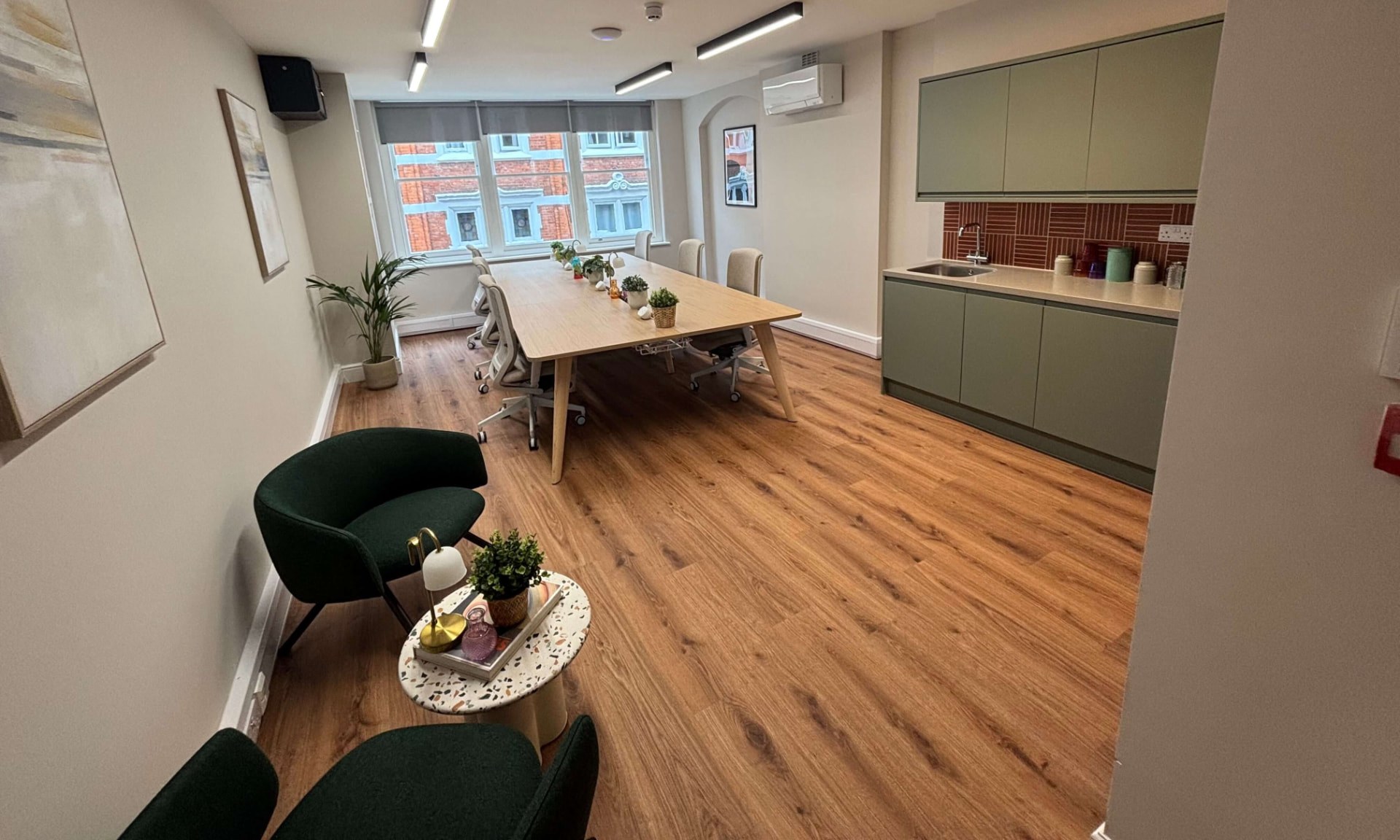 Office breakout space with meeting table and kitchen area